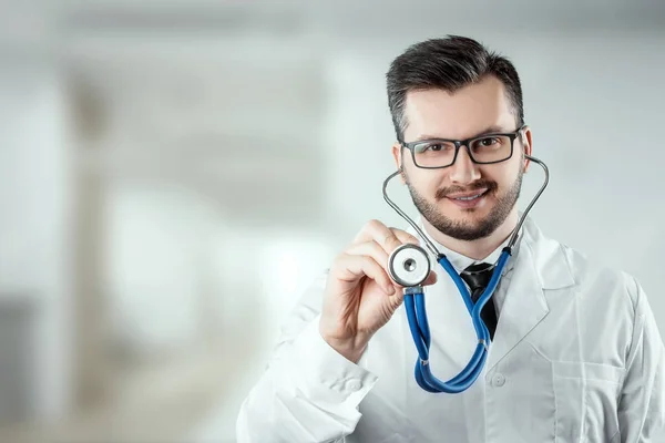 Ein Mann, ein Arzt im weißen Kittel mit Stethoskop. das Konzept der Medizin, ein Arzttermin, Gesundheitsfürsorge. Kopierraum. — Stockfoto