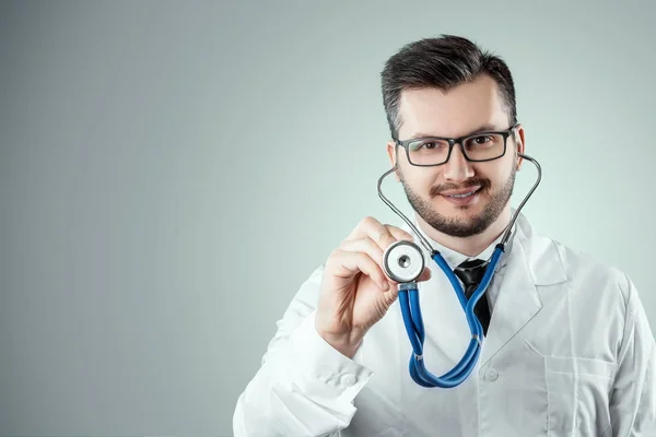 Ein Mann, ein Arzt im weißen Kittel mit Stethoskop. das Konzept der Medizin, ein Arzttermin, Gesundheitsfürsorge. Kopierraum. — Stockfoto