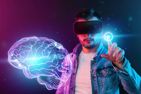 Un hombre con gafas de realidad virtual sobre un fondo oscuro, señala algo con el dedo. Concepto de realidad aumentada, gafas vr, tecnologías futuras . — Foto de Stock