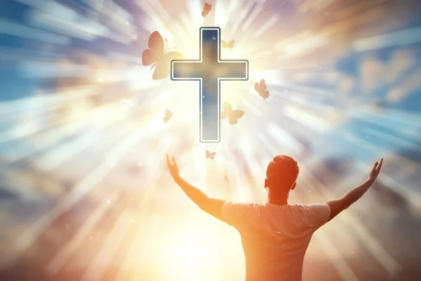 Hıristiyan sembolünün arka planındaki adam, dua, Katolik haçı. Hıristiyan din, umut kavramı, inanç, din, umut ve özgürlük sembolü. — Stok fotoğraf