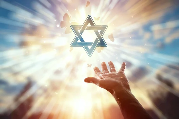 Nahaufnahme der Hände auf dem Hintergrund des Symbols des Judentums, des Gebets, des Davidsterns, einer Schmetterlingsschar. Judentum, das Konzept der Hoffnung, des Glaubens, der Religion, ein Symbol der Hoffnung und der Freiheit. — Stockfoto
