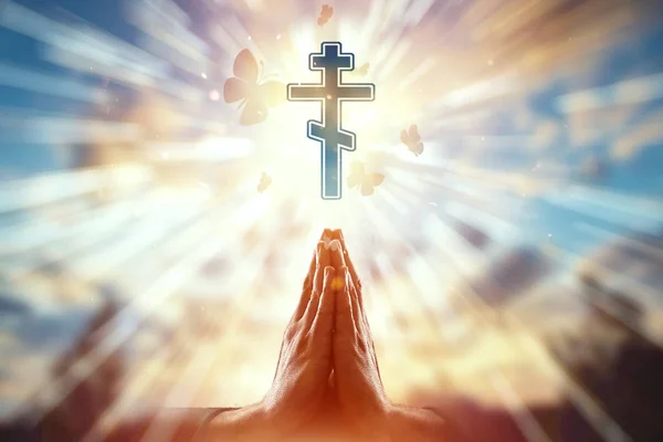キリスト教、祈り、正統派の十字架のシンボルの背景に手をクローズアップ。宗教、希望、信仰、自由の象徴の概念. — ストック写真