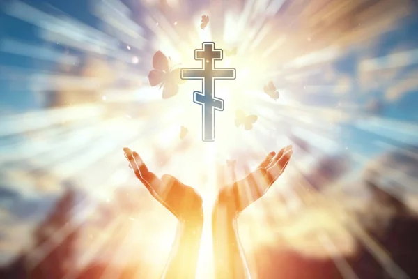 Eller Hıristiyanlık sembolü, dua, ortodoks haç arka planda yakın. Din, umut, inanç kavramı, özgürlüğün sembolü. — Stok fotoğraf
