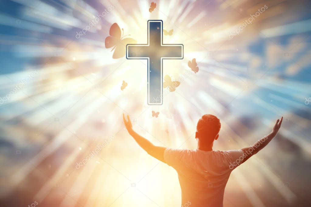 The man on the background of the symbol of Christian, prayer, the Catholic cross. Christian religion, the concept of hope, faith, religion, a symbol of hope and freedom.