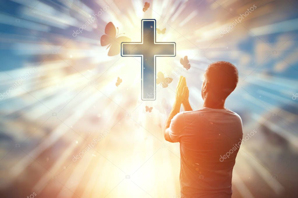 The man on the background of the symbol of Christian, prayer, the Catholic cross. Christian religion, the concept of hope, faith, religion, a symbol of hope and freedom.