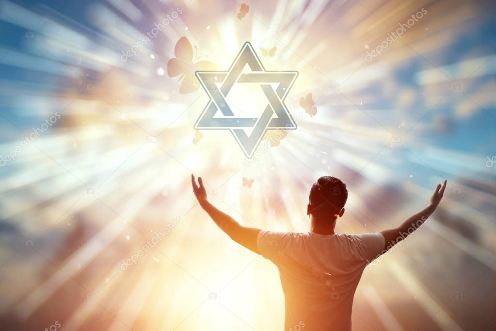 A man against the backdrop of the symbol of Judaism, a prayer, the star of David. The concept of hope, faith, religion, a symbol of hope and freedom.