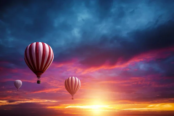 Globos multicolores y grandes en el cielo sobre el telón de fondo de una hermosa puesta de sol. Concepto de viaje, sueño, nuevas emociones . —  Fotos de Stock