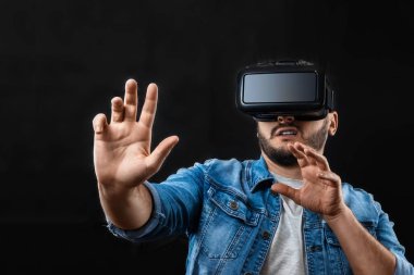 Sanal gerçeklik gözlük, vr, karanlık bir arka plan karşı bir adamın portresi. Geleceğin konsepti burada, uygulamalar gerçekliği tamamlıyor, sanal gerçeklik arabirimini. Kopyalama alanı.