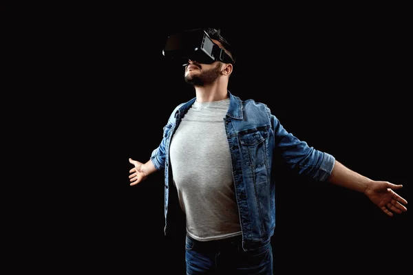 Portrait of a man in virtual reality glasses, vr, against a dark background. The concept of the future is here, applications complement reality, the virtual reality interface. Copy space.