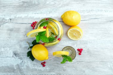 Taze limon, nane ve kızılcık ile ev yapımı limonata. Beyaz ahşap bir arka plan üzerinde bir konserve limonata. Taze limonata, soğuk meyve suyu, ısı kavramı
