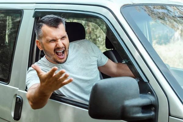 Agresivní muži, řidič auta je během cesty rozhořčeně u volantu. Pohotovost, nehoda, porušení práv, spor, špatný řidič — Stock fotografie