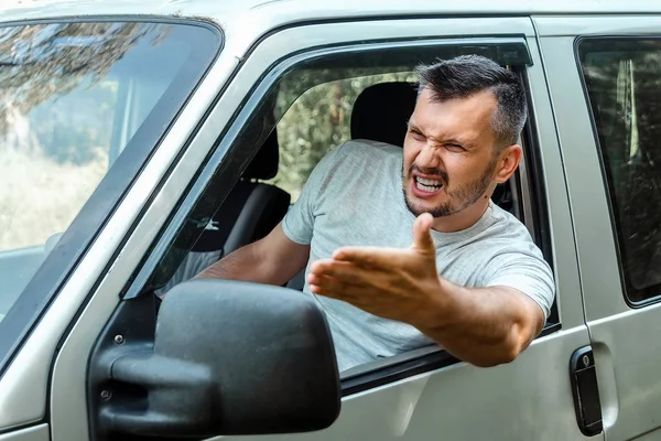 Agresivní muži, řidič auta je během cesty rozhořčeně u volantu. Pohotovost, nehoda, porušení práv, spor, špatný řidič — Stock fotografie