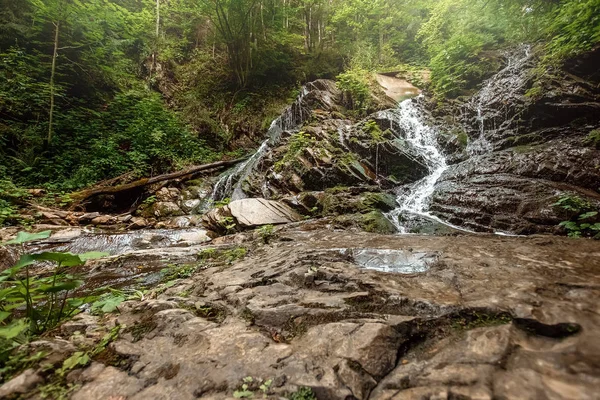 La cascade d'une cascade de rivière froide tombe sur les pierres, les cascades sur une rivière de montagne. Le concept de vacances actives, vacances — Photo