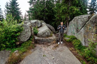 Bir adam sırt çantası olan bir turist, dağlarda yürür, yürüyüşe çıkar. Aktif tatil kavramı, seyahat, dağlarda tatil, yaşam tarzı