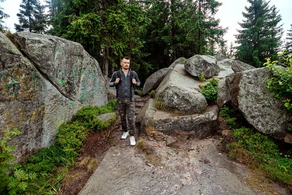 Ein Mann ist Tourist mit Rucksack, wandert in den Bergen, geht wandern. das Konzept von Aktivurlaub, Reisen, Urlaub in den Bergen, Lebensstil — Stockfoto