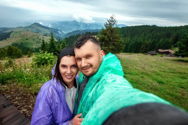 Hermosa pareja, turistas, hacer selfie, foto sobre el fondo de las hermosas montañas de los Cárpatos. Concepto de viaje, actividad de ocio, vacaciones — Foto de Stock