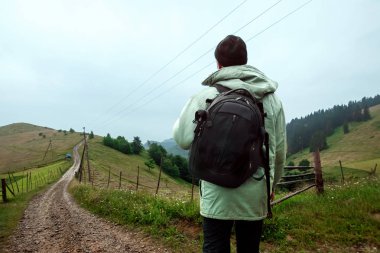Erkek turist dağlık arazinin tadını çıkarıyor. Aktif turizm, rekreasyon, Karpatlar kavramı. Kopyalama alanı
