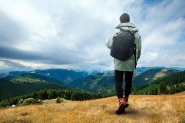 Yaratıcı arka plan, Bir adam dev, bir adam bir turist, o bir sırt çantası ile dağlık bir alanda yürür. Guliver kavramı, aktif turizm, rekreasyon, Karpatlar. Karışık ortam