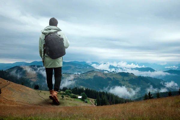 Fondo creativo, Un hombre es gigante, un hombre es un turista, camina a través de una zona montañosa con una mochila. El concepto de Guliver, turismo activo, recreación, los Cárpatos. Medios mixtos —  Fotos de Stock