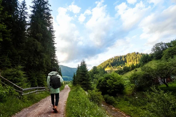 Sfondo creativo, Un turista di sesso maschile cammina attraverso una zona montuosa con uno zaino. Il concetto di turismo attivo, ricreazione, i Carpazi. Copia spazio — Foto Stock