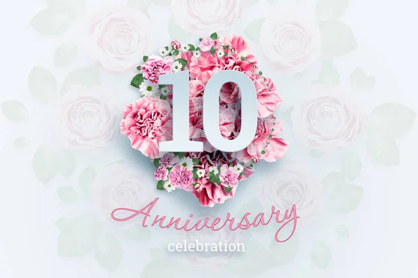 Creative background lettering 10 numbers and anniversary celebration text on pink flowers background. Anniversary concept, birthday, celebration event, template, flyer