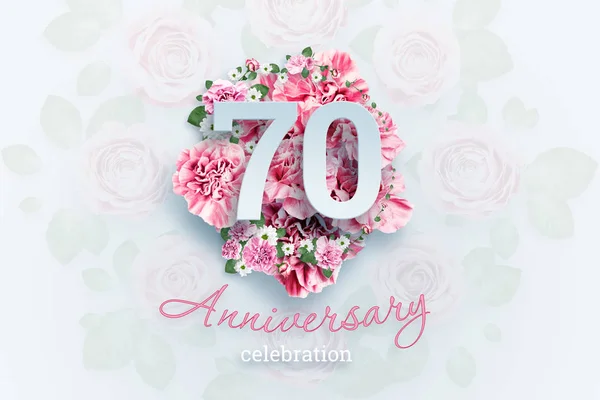 Creative background lettering 70 numbers and anniversary celebration text on pink flowers background. Anniversary concept, birthday, celebration event, template, flyer