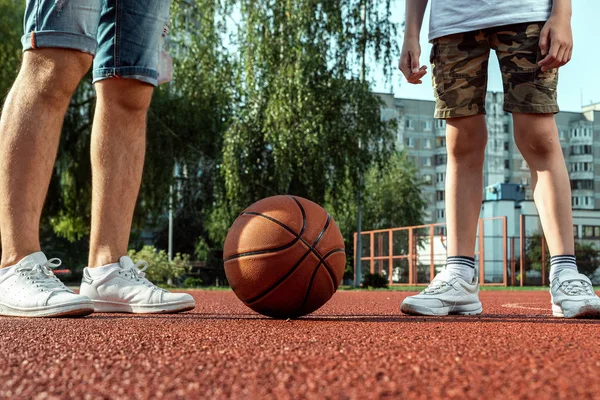 Pai e filho jogam basquete juntos na quadra de basquete. pai passa tempo com a criança, estilo de vida esportivo, treinamento, descanso, férias . — Fotografia de Stock