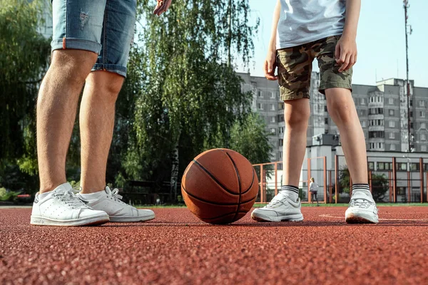 Vater und Sohn spielen gemeinsam Basketball auf dem Basketballplatz. Vater verbringt Zeit mit dem Kind, sportlicher Lebensstil, Training, Erholung, Urlaub. — Stockfoto