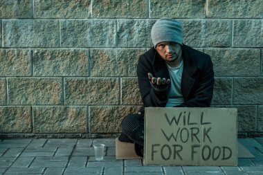 Bir adam, evsiz, bir adam bir işaret ile sokakta sadaka istiyor yiyecek için çalışacak. Evsiz kişi kavramı, bağımlı, yoksulluk, umutsuzluk.