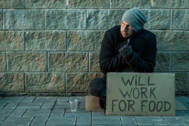 Bir adam, evsiz, bir adam bir işaret ile sokakta sadaka istiyor yiyecek için çalışacak. Evsiz kişi kavramı, bağımlı, yoksulluk, umutsuzluk.