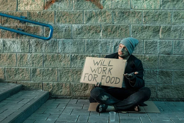Bir adam, evsiz, bir adam bir işaret ile sokakta sadaka istiyor yiyecek için çalışacak. Evsiz kişi kavramı, bağımlı, yoksulluk, umutsuzluk.