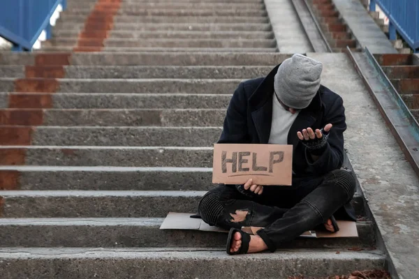 Muž, bezdomovec, se ptá na ulici s cedlky. Pojetí bezdomovců, narkoman, chudoby, zoufalství. — Stock fotografie
