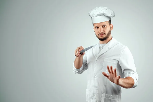 Un hombre con barba, un cocinero con sombrero y un cuchillo en la mano Aislado sobre un fondo blanco. Cocina, recetas, cocina . — Foto de Stock
