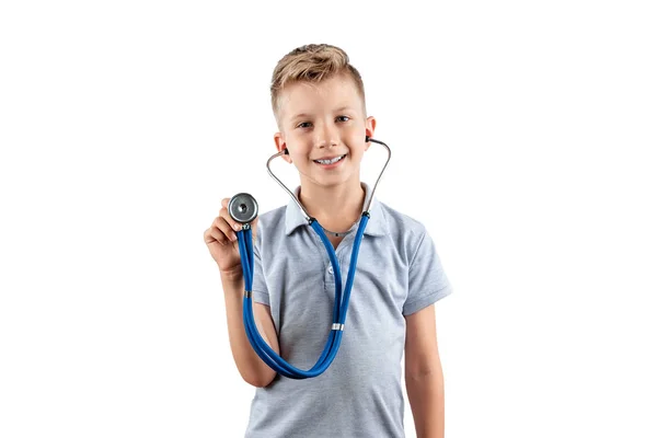 Усміхнений хлопчик тримає стетоскоп в руках на ізольованому світлому тлі. Медична освіта, вибір професії, майбутній лікар . — стокове фото