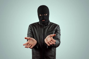 Soyguncu, bir balaclava haydut hafif bir arka plan üzerinde teslim olur. Soygun, hacker, suç, hırsızlık. Kopyalama alanı.