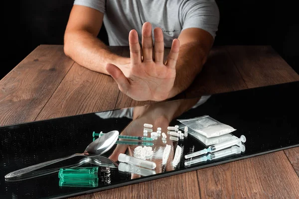 A man with a stop gesture refuses drugs, the fight against drug addiction. Social problem, drug addiction, death, addiction. Copy space. — Stock Photo, Image