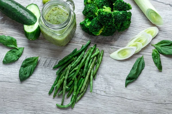 Hafif bir masada taze yeşil yemek. Avokado salatalık lahana elma fasulye kivi soğan brokoli. Sağlıklı gıda kavramı, detoks vejetaryenlik. Kopya alanı düz yatıyordu.
