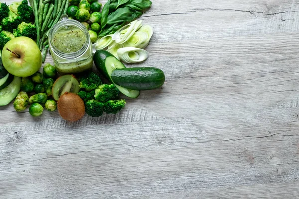 Comida verde fresca en una mesa ligera. Pepinos aguacates col manzanas frijoles kiwi cebolla brócoli. El concepto de comida saludable, desintoxicación vegetariana. Copia de espacio plano lay . — Foto de Stock