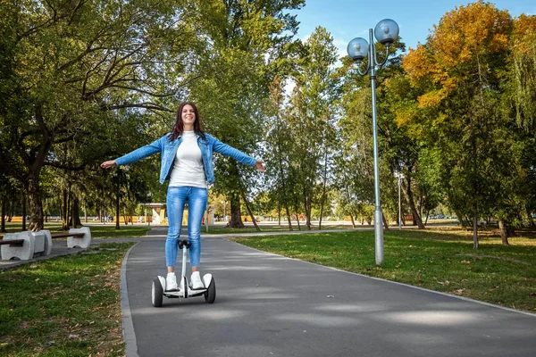 Hermosa chica en un hoverboard blanco en el parque, auto-equilibrio scooter. Estilo de vida activo tecnología futuro espacio de copia — Foto de Stock