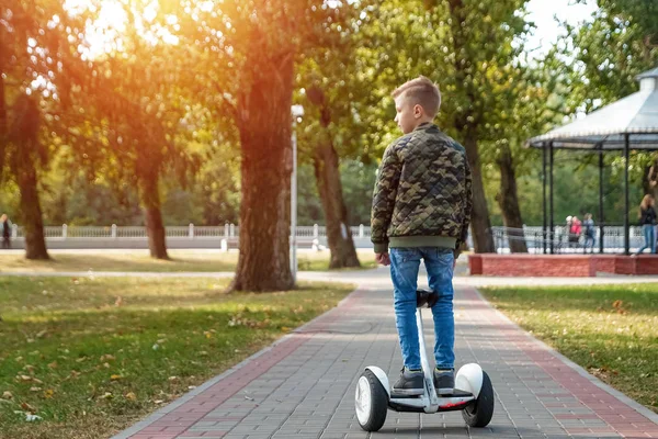 Ein Junge auf einem Hoverboard im Park, einem selbstbalancierenden Roller. Zukunft der aktiven Lifestyletechnologie — Stockfoto