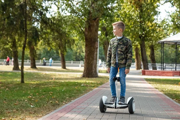 Een jongen rijden een Hoverboard in het Park, een zelfbalancerende scooter. Actieve lifestyle technologie toekomst — Stockfoto