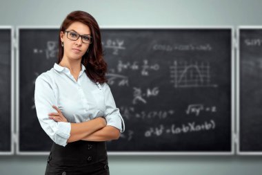 Okul tahtasının arka planında genç ve güzel bir öğretmenin portresi. Öğretmenler Günü Bilgi Günü okula geri döndü çevrimiçi öğrenim.