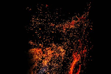 Siyah arka plandaki yangından çıkan kıvılcımlar izole edilmiş. Hafta sonu mangal partisini düşün..