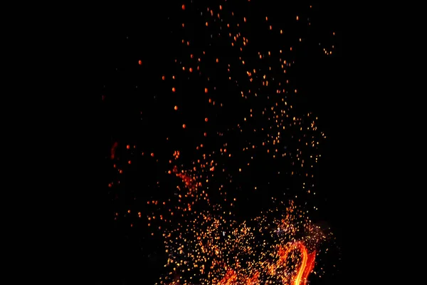 Σπινθήρες από μια πυρκαγιά σε ένα μαύρο απομονωμένο υπόβαθρο. Έννοια φωτιά σχάρα μπάρμπεκιου. — Φωτογραφία Αρχείου