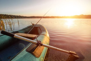 Gün doğumunda gölde şişme bot. Balıkçılık hobisi tatil konsepti. Boşluğu kopyala