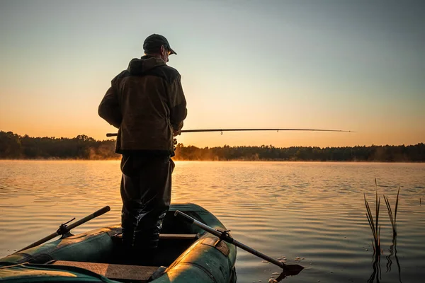 A férfi halász hajnalban a tavon fog egy horgászbotot. Horgász hobbi nyaralás koncepció. Fénymásolási hely. — Stock Fotó