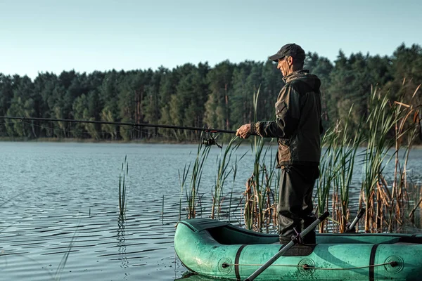 Samiec rybaka na jeziorze stoi w wodzie i poluje na wędkę. Koncepcja wakacji wędkarskich. Przestrzeń kopiowania. — Zdjęcie stockowe