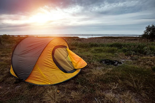 Zeltlager in Orange vor dem Hintergrund der Natur und des Sees. das Konzept von Reisen, Tourismus, Zelten. — Stockfoto