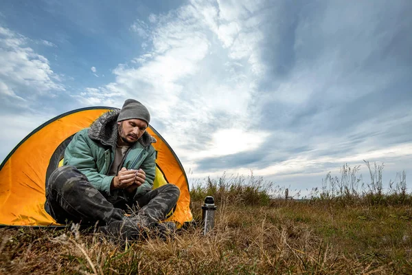 Un barbu campe dans une tente sur fond de nature et de lac. Le concept de voyage, tourisme, camping . — Photo