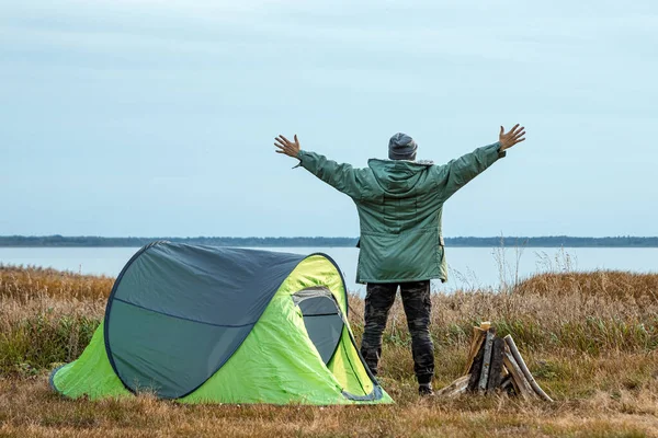 Un homme barbu près d'une tente de camping en vert sur le fond de la nature et du lac. Le concept de voyage, tourisme, camping . — Photo